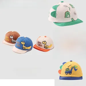 Detail of baby caps with dinosaur embroidery and soft brims in various colors