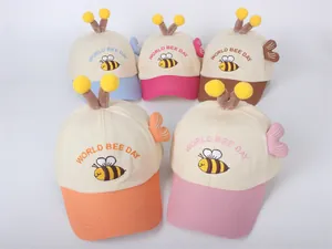 Detalle de gorras de béisbol infantiles de abejas con antenas y adornos de alas