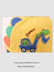 Close-up of yellow cotton cap with dinosaur embroidery and 3D decorative accents