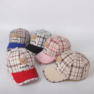 Detail of children's checkered baseball caps with 3D teddy bear patches in five colors