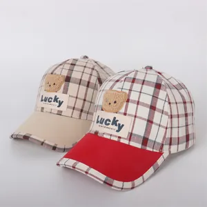 Detail of plaid cotton baseball caps for kids with Lucky bear patches and embroidery