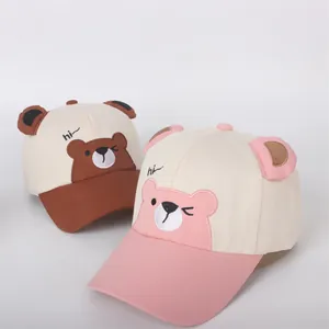 Detail of cartoon bear patch and 3D ears on cotton baseball caps for toddlers