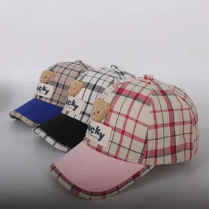 Three children's plaid baseball caps featuring cute plush bears and Lucky patches