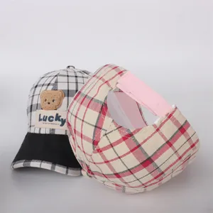 Detail of plaid kids baseball cap with plush bear patch and adjustable velcro strap