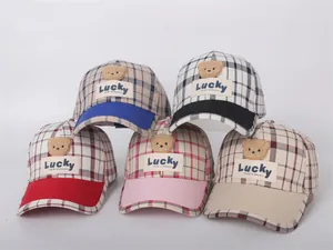 Selection of five plaid children's baseball caps with Lucky bear patches and varied brims