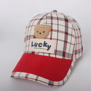 Detail of red checkered kids baseball cap with plush bear patch and Lucky embroidery