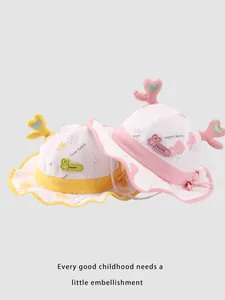 Dettaglio di cappelli da sole rosa e gialli per neonati con orecchie di coniglio lucide