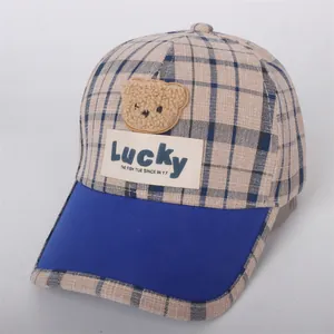 Detail of children's baseball cap with teddy bear patch and lucky woven label text