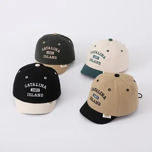 Flat lay of cotton baby baseball caps with vintage embroidery in four contrast colors