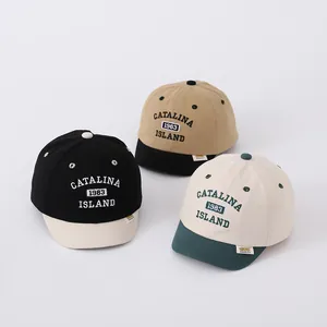 Detailed close-up of baby canvas baseball caps showing color-block designs and letter embroidery