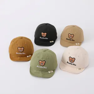 Detail of five baby baseball caps in diverse colors featuring cute bear embroidery patches