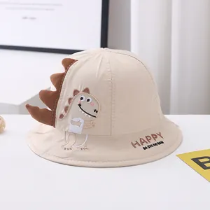 Close-up of cotton sun hat featuring cartoon dinosaur embroidery and textured spines