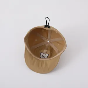 Interior view of khaki baby baseball cap showing breathable holes and bear embroidery