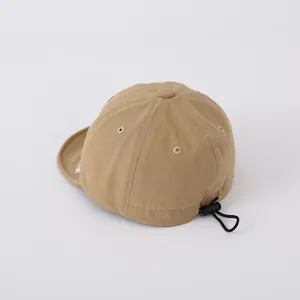 Detail of baby khaki baseball cap featuring breathable cotton fabric and elastic toggle