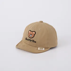Detail of khaki cotton baby baseball cap featuring brown bear embroidery and soft brim