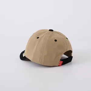 Detail of khaki cotton baseball cap with black velcro strap and brand woven label