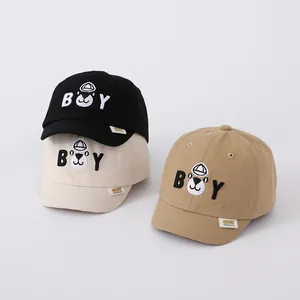 Detail of cotton baby baseball caps featuring BOY embroidery and cute character patches