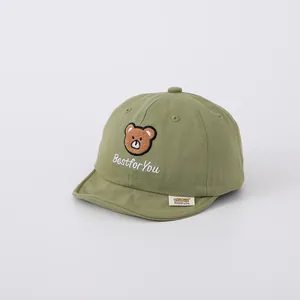 Detail of baby cotton baseball cap with cute bear embroidery and short brim in olive green