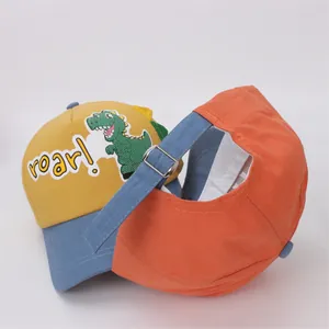 Detail of kids baseball cap showing cartoon dinosaur embroidery and adjustable metal buckle