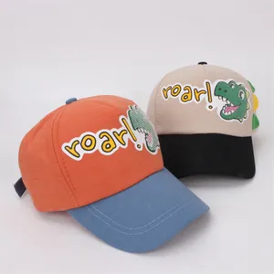 Detail of kids baseball caps featuring cartoon dinosaur patches and roar embroidery
