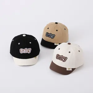 Detailed view of three baby baseball caps with soft brims and embroidered baby letters
