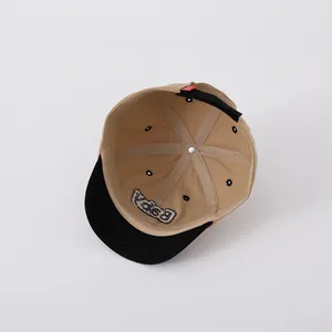 Detail of khaki two-tone baby baseball cap showing internal seams and embroidery
