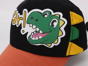 Detail of dinosaur embroidery and 3D fin design on kids baseball cap in black and orange
