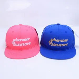 Close-up of pink and blue kids snapback hats with embroidered letter details
