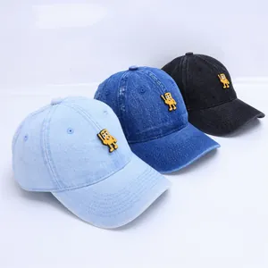 Détail de trois casquettes de baseball en jean pour bébé avec badges de dessins animés bleus