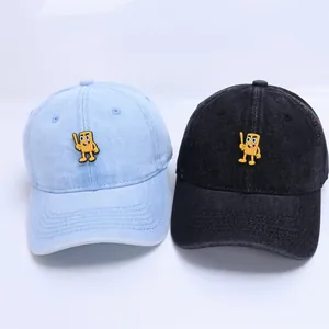 Détail de casquettes de baseball en jean bleu et noir pour bébé avec écusson de dessin animé