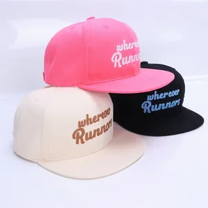 Detail of snapback caps featuring wherever Runners embroidery in pink, beige and black