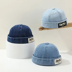 Detailed close-up of three shades of denim docker hats for kids with letter embroidery