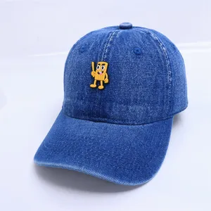 Détail d'une casquette en denim bleu avec écusson de dessin animé et bords vintage usés