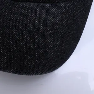 Macro detail of dark denim fabric and reinforced stitching on the baby baseball cap brim