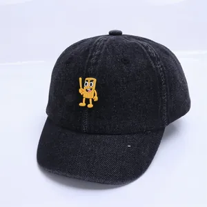 Détail de la casquette de baseball bébé en denim noir délavé avec écusson de personnage