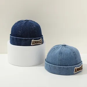 Detail view of navy and light blue denim brimless docker hats with ANGELS embroidery