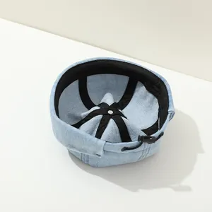 Detail view of denim beanie hat showing adjustable drawstring and black inner lining