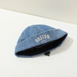 Detail of adjustable elastic drawstring toggle on a denim baby docker hat