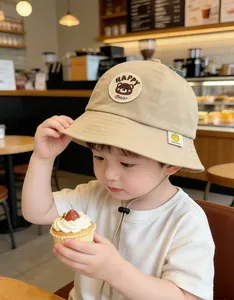 Detail of baby bear bucket hat with happy bear embroidery and yellow smiley face tag