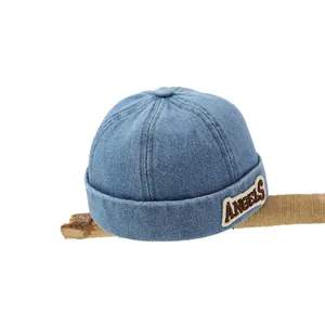Light blue denim miki hat for kids with ANGELS embroidery on a natural wood branch