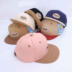 Detail view of colorful flat brim hip hop caps with 'NICE' embroidered patches