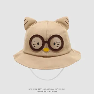 Detailed macro view of khaki cotton kids bucket hat with cat ears and glasses embroidery