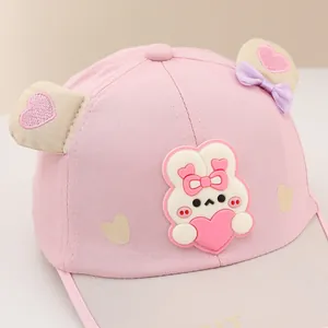 Detailed macro view of pink baby baseball cap with 3D bunny ears and heart motif