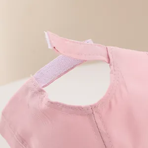 Detail showing the adjustable hook-and-loop strap on the pink canvas baby baseball cap