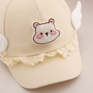 Mignonne casquette beige pour bébé avec broderie d'ours, bord en dentelle et ailes blanches