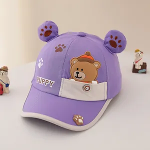 Detail of children's purple bear cap featuring 3D ears, rainbow button, and puppy embroidery