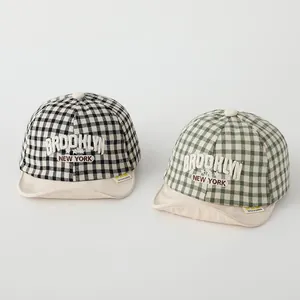Close-up of checkered baby baseball caps with 3D Brooklyn and New York embroidery