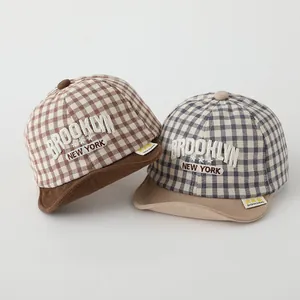 Detail view of cotton checkered baby baseball caps with Brooklyn embroidery in two colors