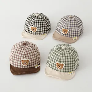 Detail showing four checkered baby baseball caps in black, grey, brown, and green colors