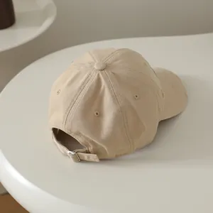 Détail de la boucle en métal et des bords usés vintage sur la casquette beige pour enfants